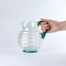 Size demonstration of Iridescent Ribbed Glass Jug with Blue-Green Handle