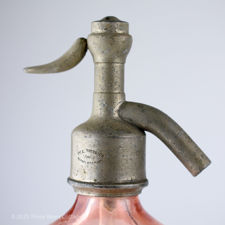Right side of the metal top of a G Gaulin à Auxon pink glass siphon